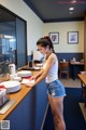 A woman standing at a counter in a restaurant.