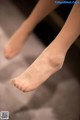 A close up of a woman's bare feet on a bed.