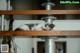 A small kitten sleeping on top of a wooden shelf.