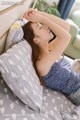 A woman laying on a bed with her head on a pillow.