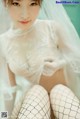 A woman in a wedding dress and fishnet stockings posing for a picture.