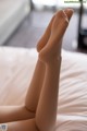 A close up of a doll's legs on a bed.