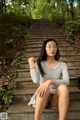 A woman sitting on the steps of a set of stairs.