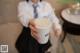 A woman holding a cup of coffee with a straw in it.