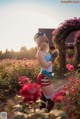 A woman in a blue top and red shorts standing in a field of flowers.