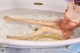 A woman in a bathtub with her legs in the water.