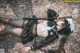 A woman laying on the ground holding a sword.