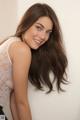 A woman with long brown hair posing for a picture.