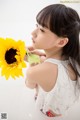 A little girl holding a sunflower in her hand.