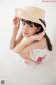 A woman in a straw hat is posing for a picture.