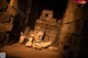 A woman laying on the ground next to a pile of skulls.