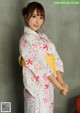 A woman in a white kimono posing for a picture.