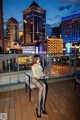 A woman sitting on a chair on a balcony at night.