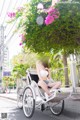 A woman sitting on the back of a rickshaw on a city street.