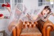 A woman in a wedding dress laying on a brown leather chair.