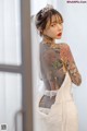 A woman in a wedding dress with tattoos on her back.