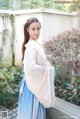 A woman in a blue and white hanbok posing for a picture.