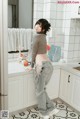 a woman standing in a kitchen next to a refrigerator