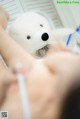 A woman getting a facial massage with a teddy bear.